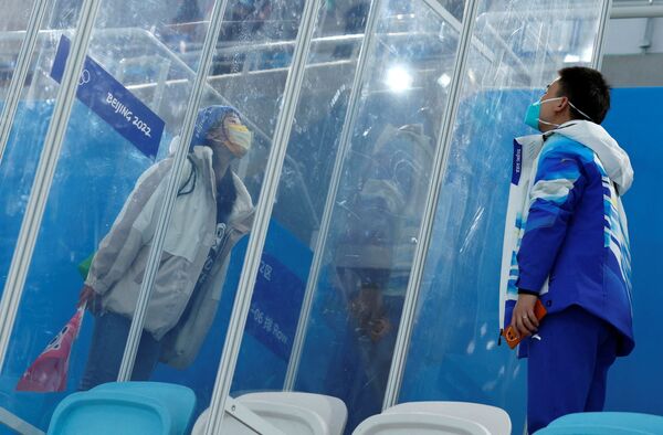 Доктор Динг Хогтао, член медицинской бригады на Олимпиаде, посылает воздушный поцелуй своей девушке, пришедшей посмотреть соревнования, через защитные экраны на стадионе, установленные как средство защиты от коронавирусной инфекции.  - Sputnik Узбекистан