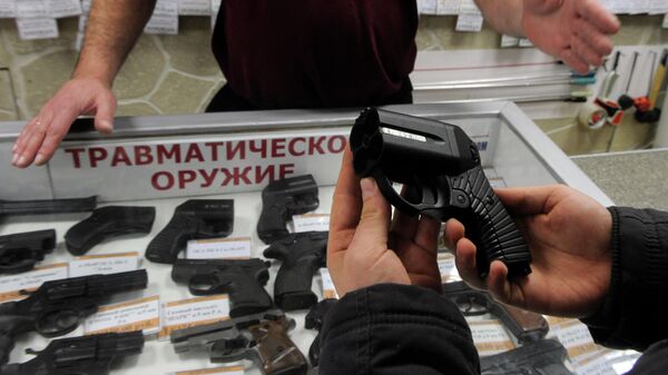 Покупатель осматривает травматический пистолет, архивное фото - Sputnik Ўзбекистон
