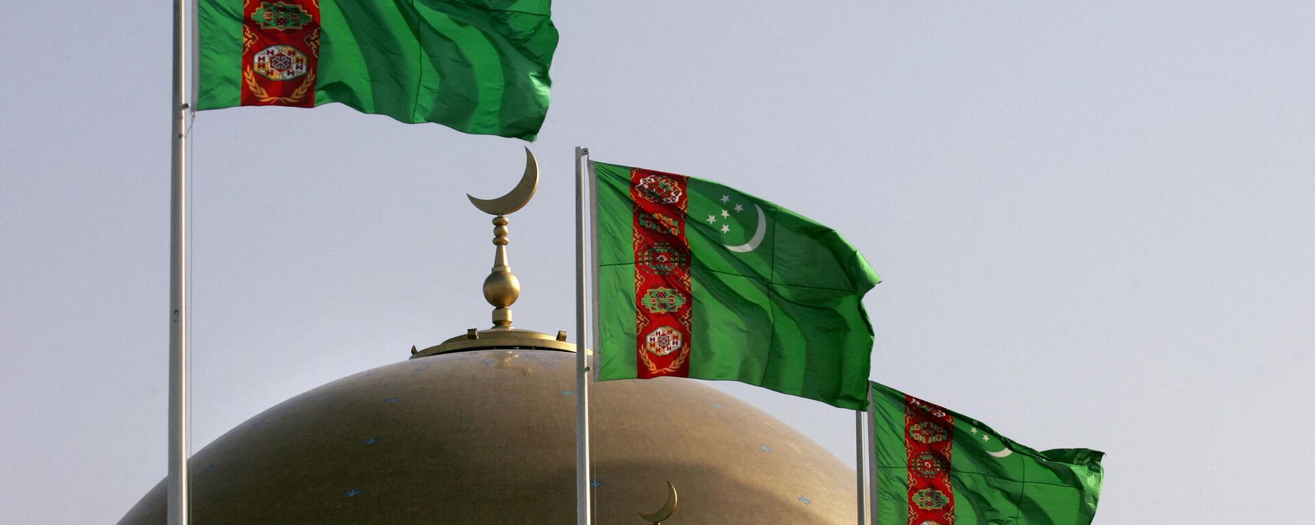 Turkmen national flags fly on July 3, 2008 over a mosque in Kipchak, 15 kms outside the capital Ashgabat - Sputnik Ўзбекистон, 1920, 15.02.2022