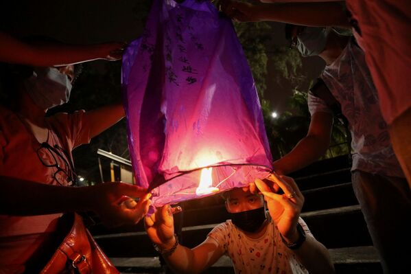 Посетители выпускают небесный фонарик на фестивале фонарей в Малайзии, 15 февраля 2022 г.  - Sputnik Узбекистан