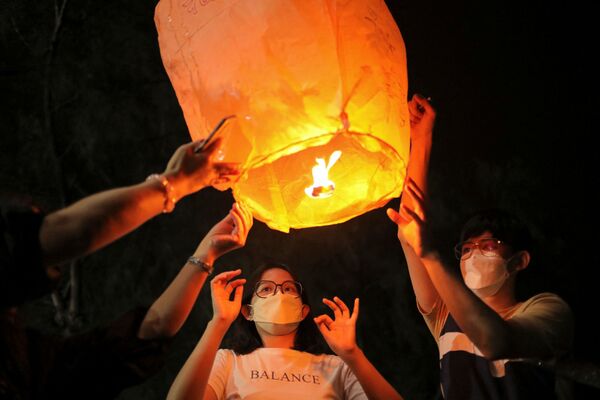 Посетители выпускают небесный фонарик на фестивале фонарей в Малайзии, 15 февраля 2022 г. - Sputnik Узбекистан