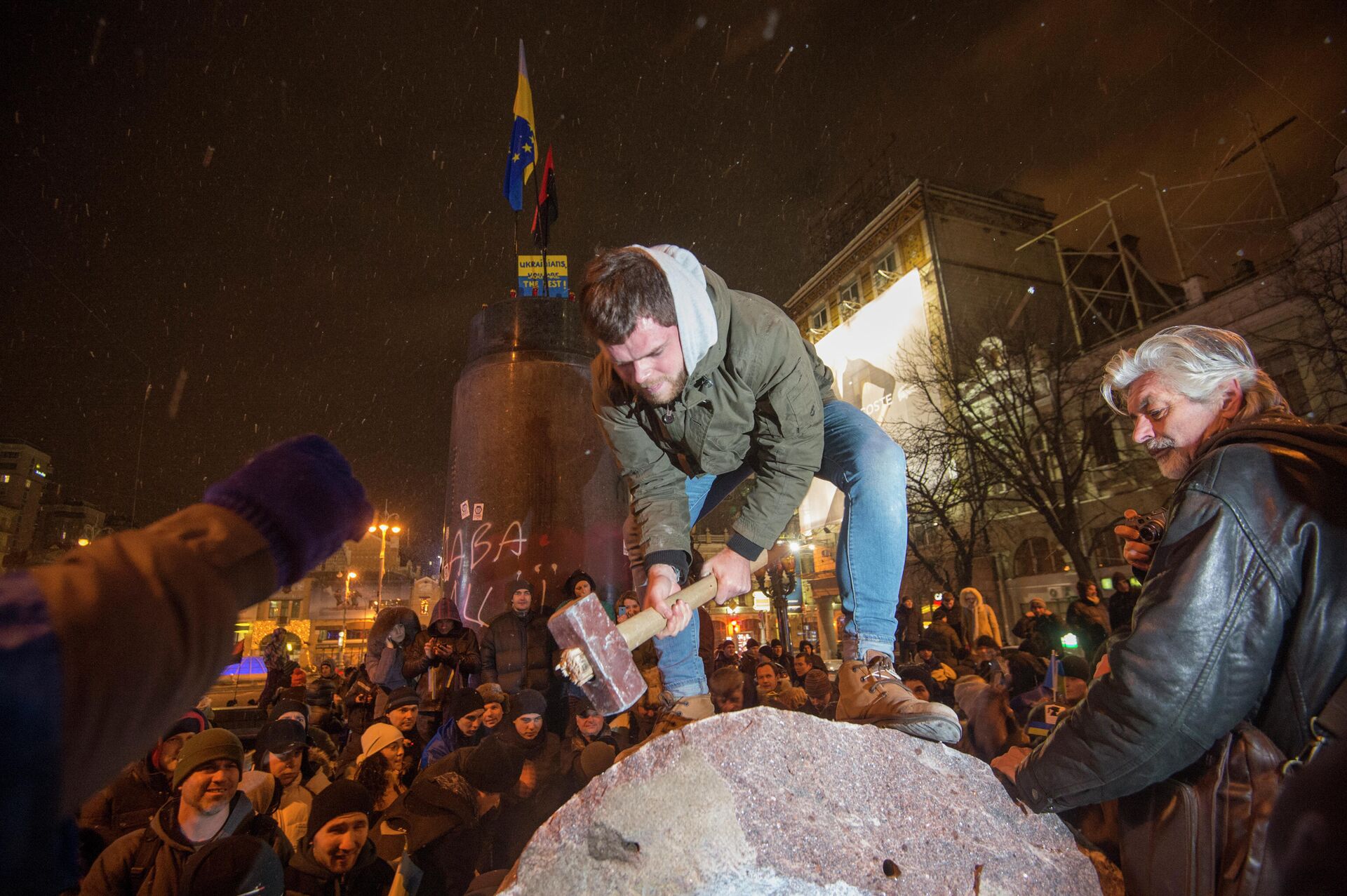 Участники акции в поддержку евроинтеграции Украины раскалывают молотками на куски памятник Ленину, снесенный ими с постамента на Бессарабской площади в центре Киева - Sputnik Узбекистан, 1920, 22.02.2022