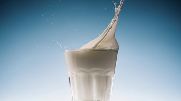 Молоко течет в стакане молока на голубом фоне - Sputnik Узбекистан