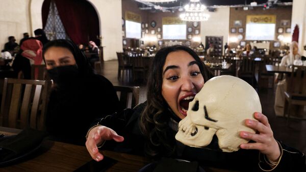 Женщина позирует с бутафорским черепом в ресторане ужасов Shadows в Эр-Рияде, Саудовская Аравия - Sputnik Узбекистан