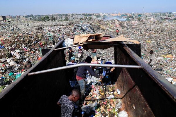 Люди ищут пластик для переработки в мусоровозе для бытовых отходов. - Sputnik Узбекистан