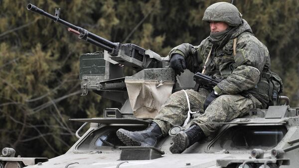 Российский военнослужащий в колонне военной техники на шоссе возле границы с Украиной в Армянске - Sputnik Узбекистан