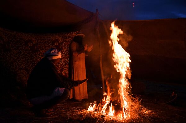 Семья кочевников греется возле костра после сильного ливня. - Sputnik Узбекистан