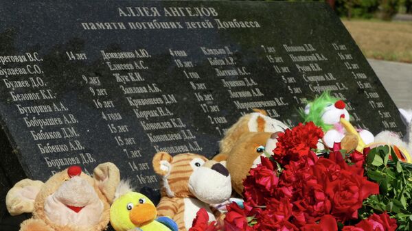 Цветы и игрушки, возложенные к памятнику Аллея Ангелов в парке Победы Калининского района Донецка во время акции в память о детях, погибших в ходе конфликта на юго-востоке Украины - Sputnik Узбекистан