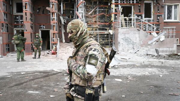 Военнослужащие во дворе многоэтажного жилого дома в Донецке, поврежденного в результате обстрела - Sputnik Узбекистан