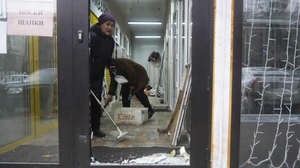 Продавцы убирают магазин, который был взломан и разграблен во время столкновений в Алматы - Sputnik Узбекистан
