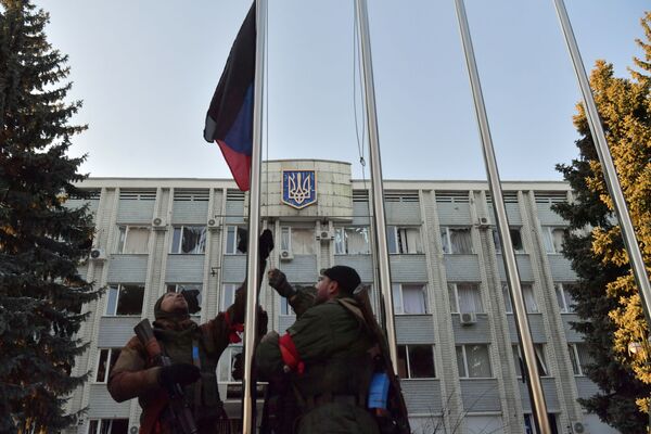 Бойцы Народной милиции ДНР поднимают государственный флаг Донецкой народной республики в Волновахе - Sputnik Узбекистан