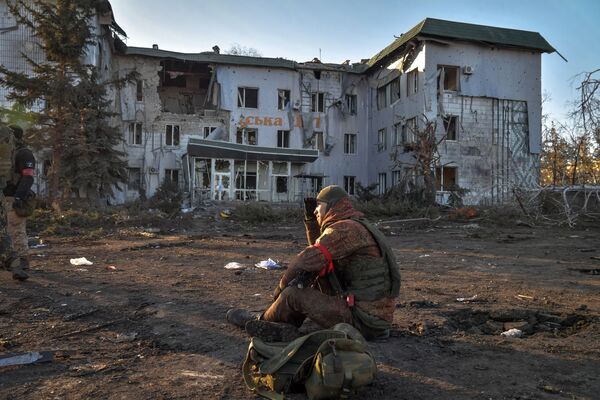 Боец Народной милиции ДНР у здания городской больницы, разрушенного в результате обстрела в Волновахе - Sputnik Узбекистан