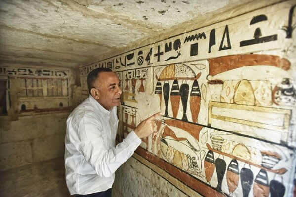 Глава Верховного совета древностей Египта Мустава Вазири осматривает роспись стен древней гробницы.  - Sputnik Узбекистан