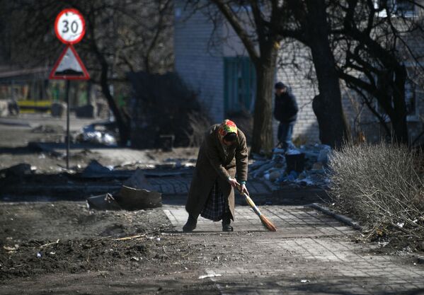 Женщина подметает улицу в Волновахе - Sputnik Узбекистан