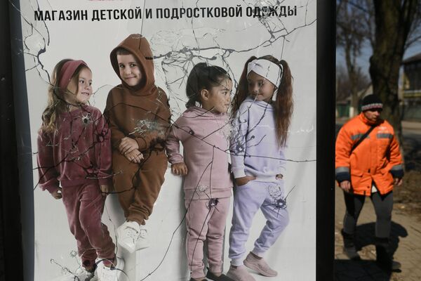 Поврежденный рекламный щит магазина детской и подростковой одежды в Волновахе - Sputnik Узбекистан