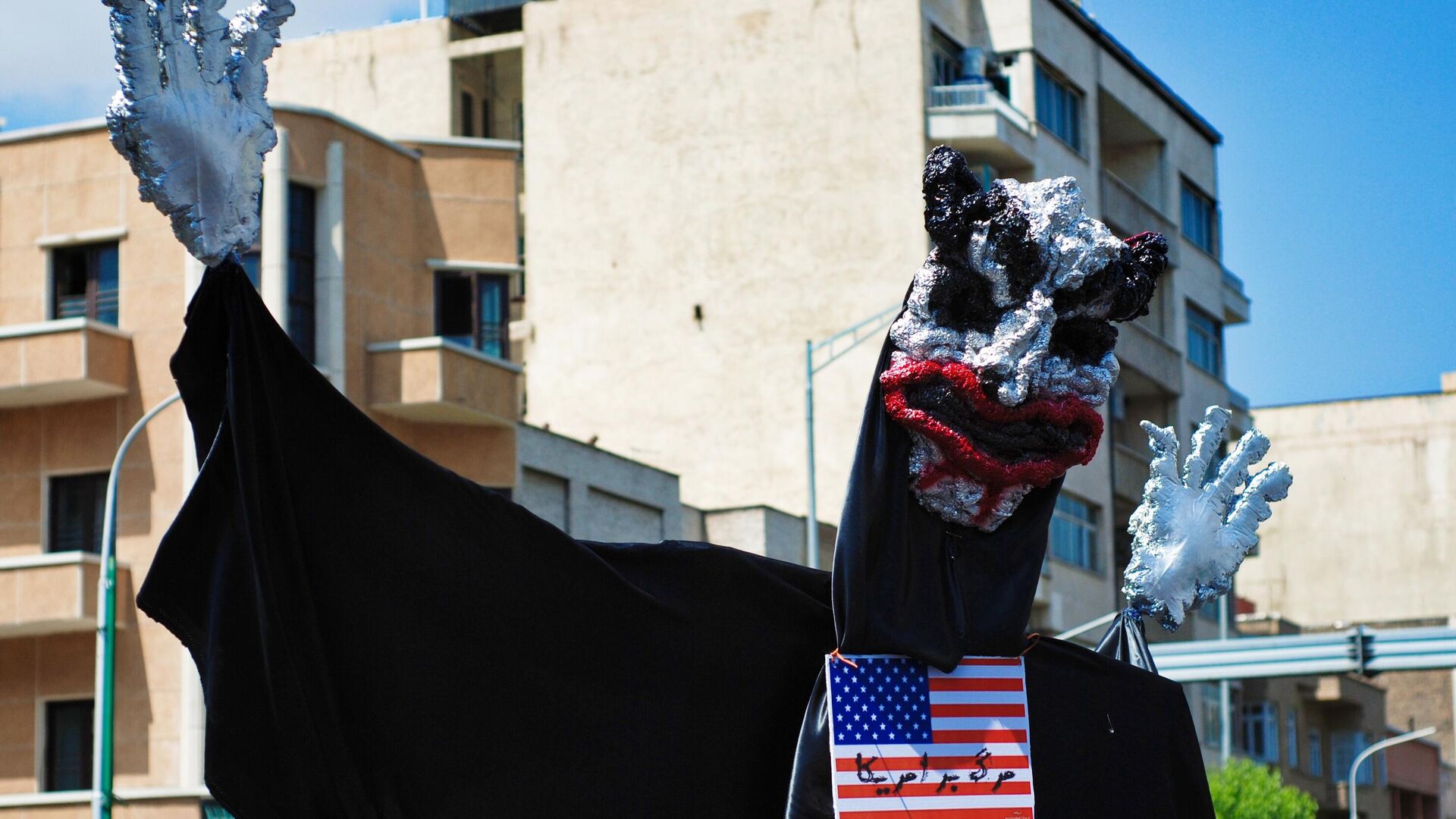 Чучело с американским флагом на шее во время политической акции в Тегеране. - Sputnik Узбекистан, 1920, 22.03.2022