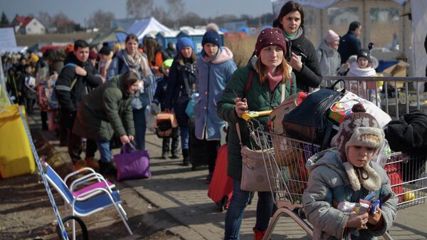 People walk to take further transportatipon after crossing the Ukrainian border into Poland in Medyka, southeastern Poland, on March 13, 2022. - Sputnik O‘zbekiston