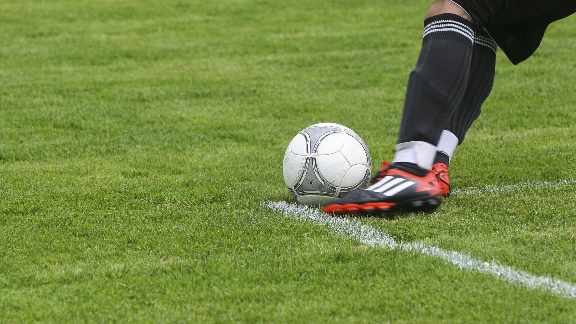 Футболист ногами белый серый футбольный мяч на поле зеленой травы - Sputnik Узбекистан, 1920, 15.05.2022