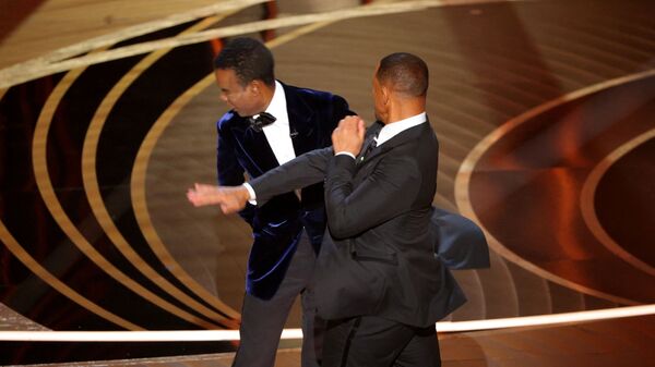 Уилл Смит (справа) ударяет Криса Рока, когда Рок выступал на сцене во время 94-й церемонии вручения премии &quot;Оскар&quot;. - Sputnik Узбекистан