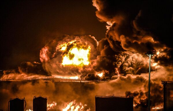 Дым и пламя поднимаются над нефтяным предприятием Saudi Aramco в городе Джидда на побережье Красного моря в Саудовской Аравии. - Sputnik Узбекистан