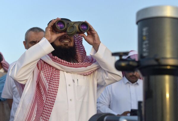 Житель Саудовской Аравии смотрит в бинокль, чтобы увидеть первый восход полумесяца Рамадана. Таиф, Саудовская Аравия. - Sputnik Узбекистан