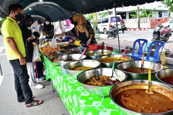 Верующие покупают еду для разговения на уличном базаре в Таиланде. - Sputnik Узбекистан