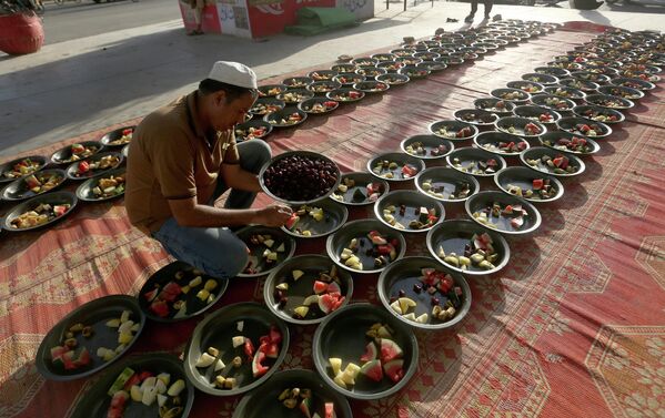 Волонтер готовит порции еды для бесплатной раздачи верующим в Карачи, Пакистан. - Sputnik Узбекистан