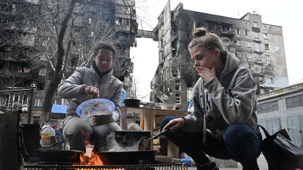 Жители Мариуполя готовят еду во дворе разрушенного дома  - Sputnik Ўзбекистон