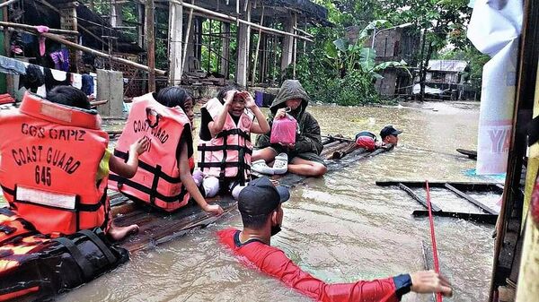 Спасатели эвакуируют жителей из затопленной деревни в Панитане, Филиппины - Sputnik Ўзбекистон