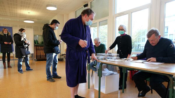 Избиратель в халате и тапочках прибывает на избирательный участок в Реймсе, Франция - Sputnik Узбекистан