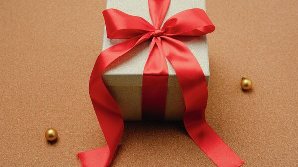 Красно-белая подарочная коробка в клетку с красной лентой - Sputnik Ўзбекистон