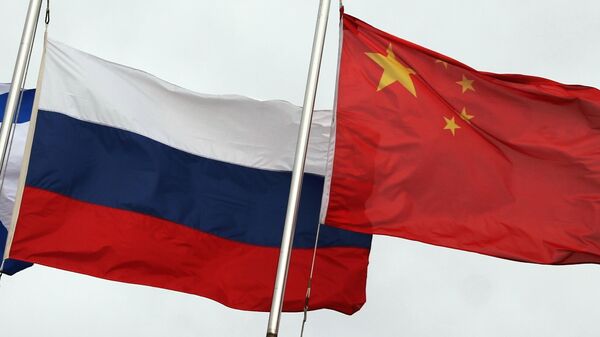 Государственные флаги России (слева) и Китая во время церемонии открытия Армейских международных игр — 2021 (АрМИ-2021) во Владивостоке - Sputnik Узбекистан