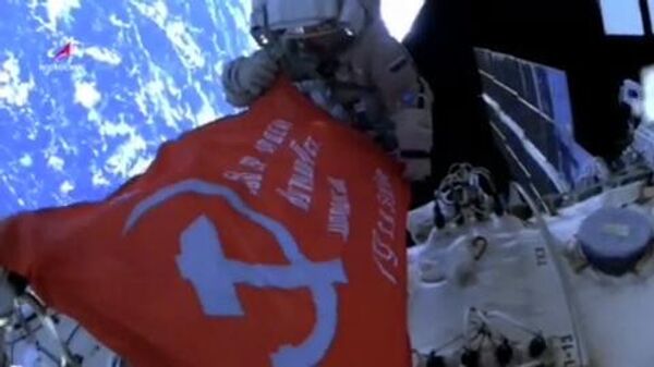 В открытом космосе  российские космонавты развернули Знамя Победы в ВОВ - Sputnik Ўзбекистон