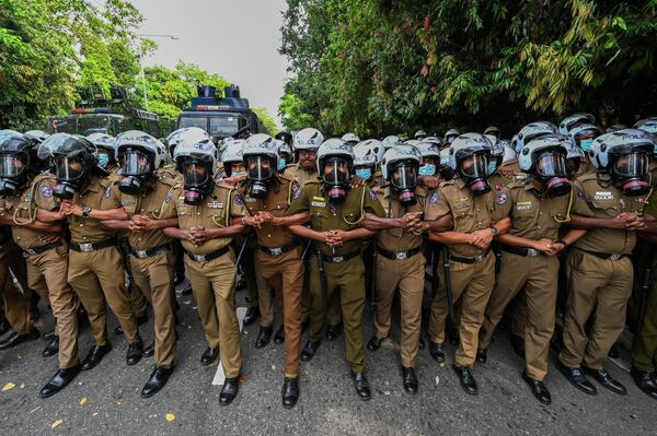 Полицейские стоят на страже во время демонстрации студентов возле здания парламента в Коломбо, Шри-Ланка. - Sputnik Узбекистан