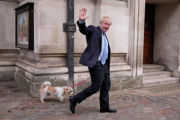 Премьер-министр Великобритании Борис Джонсон со своей собакой после голосования на избирательном участке в Лондоне. - Sputnik Узбекистан