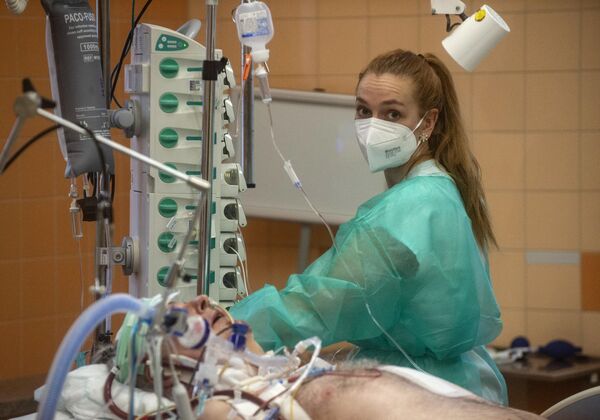 Медсестра лечит пациента, зараженного коронавирусом, в одной из больниц Праги (Чехия). - Sputnik Узбекистан