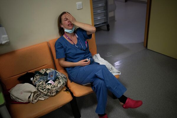 Медсестра Мари-Лора Сатта делает паузу во время своей новогодней смены в отделении интенсивной терапии COVID-19 в больнице Ла Тимон в Марселе, на юге Франции. - Sputnik Узбекистан