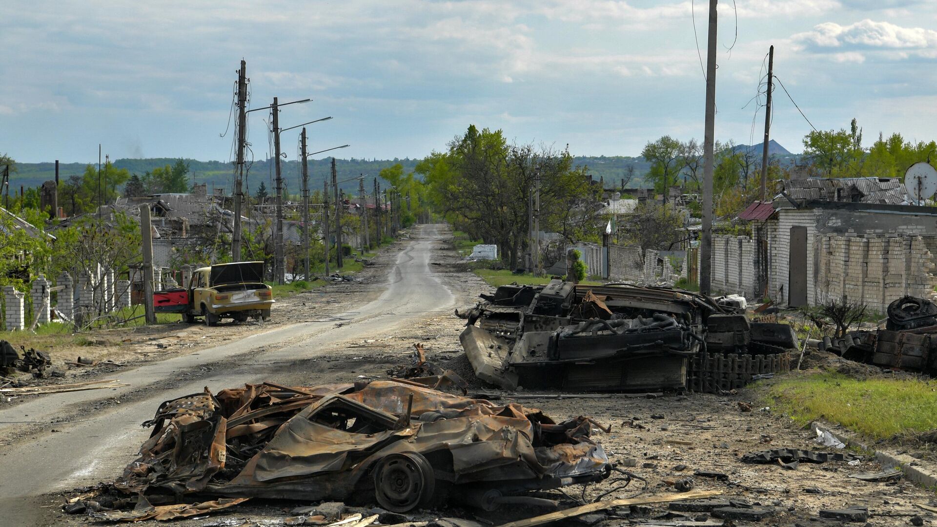 Сгоревшая военная техника и автомобили на одной из улиц в городе Рубежное - Sputnik Узбекистан, 1920, 13.05.2022