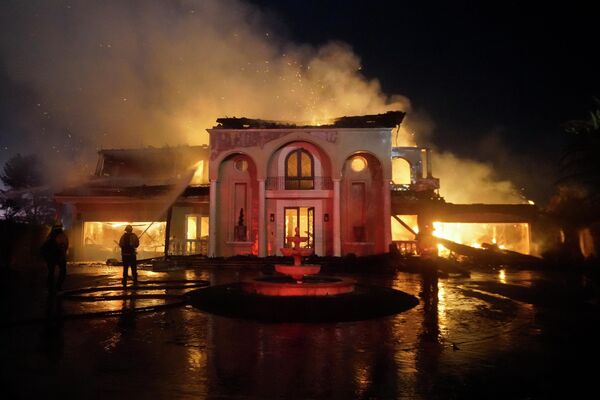 Пожарные тушат горящее здание 11 мая 2022 года во время пожара в городе Лагуна Нигель в Калифорнии.  - Sputnik Узбекистан