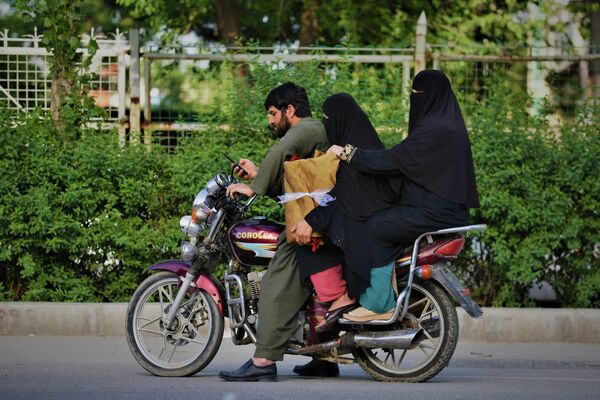 Женщины в никабе едут на мотоцикле в сопровождении родственника. - Sputnik Узбекистан