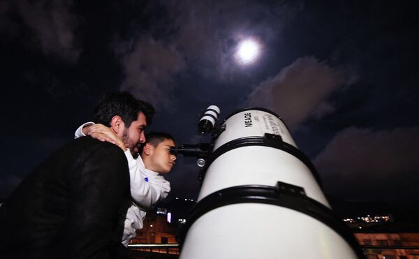 Люди наблюдают за затмением в Боготе, Колумбия. - Sputnik Узбекистан