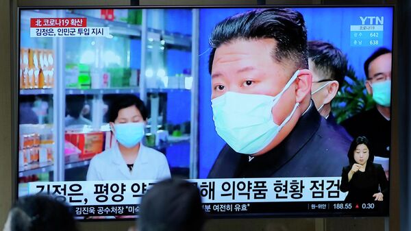 Ким Чен Ын в маске на экране телевизора. - Sputnik Узбекистан
