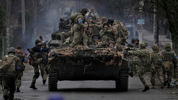 Украинские военнослужащие поднимаются на боевую машину под Киевом - Sputnik Узбекистан