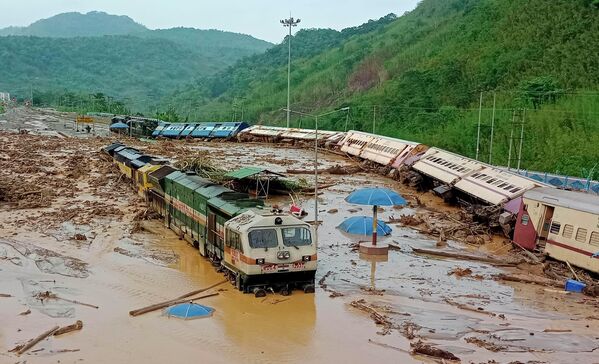 Вагоны поездов опрокинуты после оползней, вызванных проливными дождями, на железнодорожной станции на северо-востоке штата Ассам, Индия. - Sputnik Узбекистан