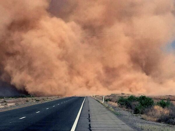 На этом архивном фото, сделанном в 2016 году, показана пыльная буря в штате Аризона, США. В результате движение по автомагистрали было остановлено на несколько дней.  - Sputnik Узбекистан