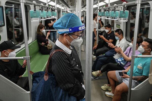 Люди едут в метро в районе Цзинъань в Шанхае 1 июня 2022 года после окончания карантина. - Sputnik Узбекистан