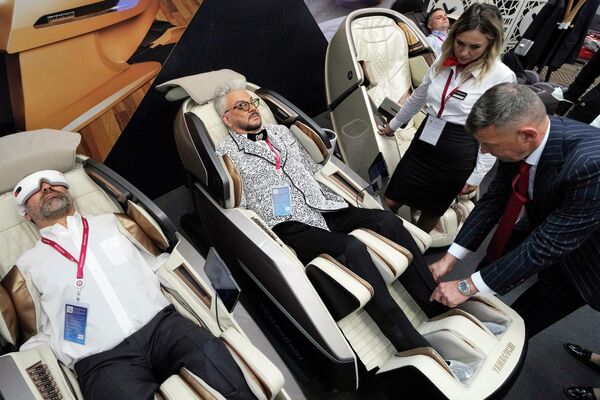 Филипп Киркоров тестирует массажное кресло, представленное на форуме. - Sputnik Узбекистан