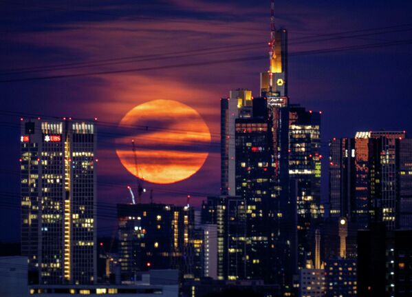 Полная луна восходит за зданиями в банковском районе Франкфурта, Германия, поздно вечером во вторник, 14 июня 2022 года. - Sputnik Узбекистан