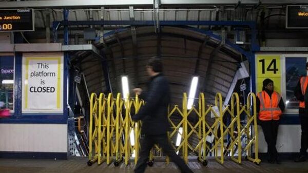 Пассажир проходит мимо закрытого входа на платформу станции Клэпхем-Джанкшен во время забастовки железнодорожников в Лондоне - Sputnik Узбекистан