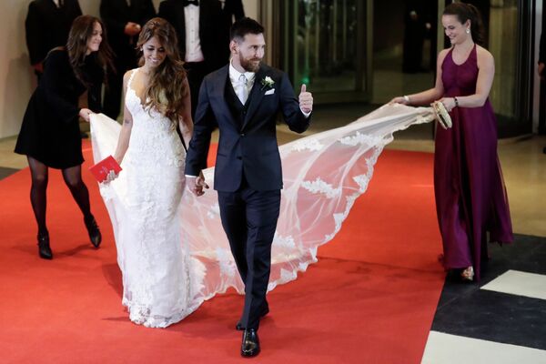 Новобрачный Лионель Месси показывает большой палец вверх, когда он и его невеста Антонелла Рокуццо выходят на красную дорожку, чтобы позировать фотографам после того, как связали себя узами брака на гражданской церемонии в Росарио, Аргентина, 30 июня 2017 года. - Sputnik Узбекистан